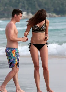 Babe in black bikini on the beach with her boyfriend