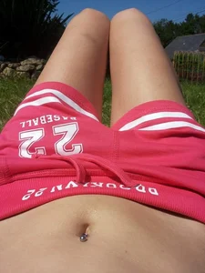 Closeup Selfie of a Girl's Tummy And Skinny Legs in Shorts, Lying on the Grass
