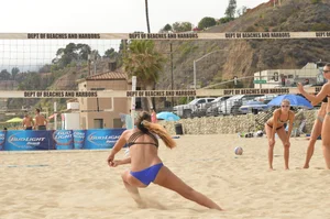 Sexy beach volleyball girl in sport bra top with pokies and blue bikini bottom