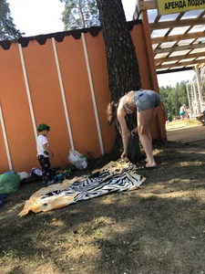 Young Skinny Girl Taking Off Her Denim Shorts Leaving a Swimsuit - Bending Over While Laying a Blanket on the Ground at a Lake Nature Park Gallery