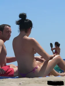 Purple thong topless lady on the beach gets oiled up by her husband