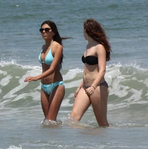 Brunette and redhead on the beach in bikinis looking sexy