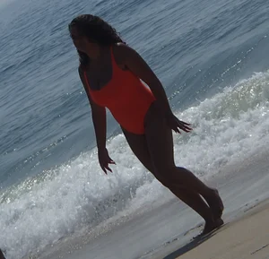 Beach girl with big boobs in an orange swimsuit