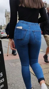 Brunette beauty with a slender waist in tight jeans