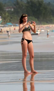 Babe in black bikini on the beach with her boyfriend