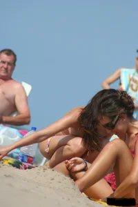2 topless girls at the beach in thongs