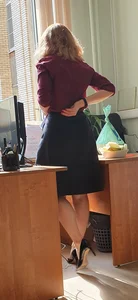Hot teacher wearing stiletto heels and a skirt in classroom
