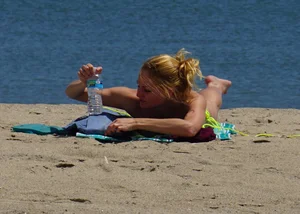 Sexy ass blonde milf on the beach in a thong with cameltoe and bending over