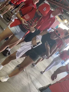 Bunch of girls in various outfits at a Cardinals baseball game