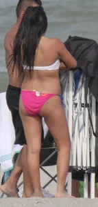 Brunette bikini girl on the beach and surfing in her bikini
