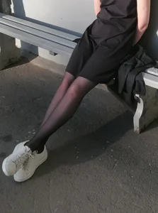 Girl with Skinny Legs in Black Pantyhose Sitting on the Bus Stop Candid