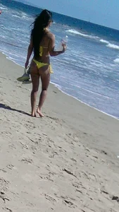 Beach babe with a nice ass and big tits in yellow thong bikini