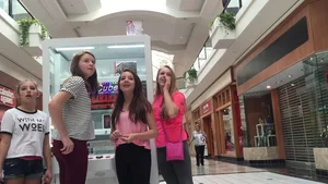 Little blonde teen in grey leggings at the mall with her friends