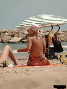 Tattooed blonde with big tits topless and in thong