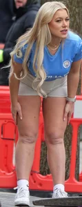 Curvy blonde girl in soccer / football kit & shorts poses for photos