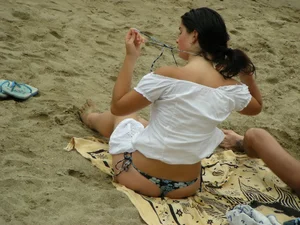 Sexy girl in a blue floral thong bikini at the beach