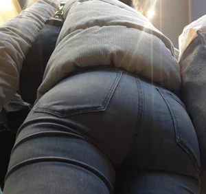 Girl with a tight ass in grey jeans going up the escalator
