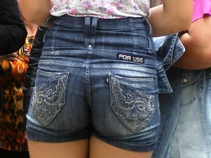 Redhead girl with her cheeks eating her denim shorts