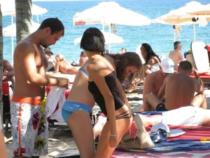 Topless cutie at the beach with a tight little ass in a thong