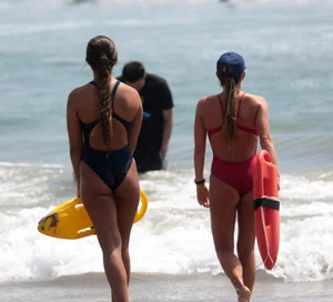 Two sexy lifeguards in red and blue swimsuits