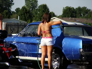 Group of cute girls at a car wash in bikinis and shorts