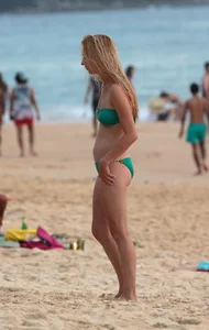 Sexy brunette in thong bikini and blonde friend in green bikini at the beach