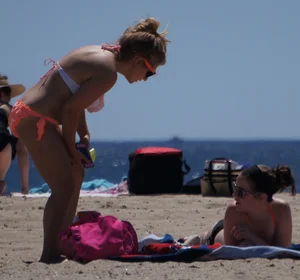 Thick blonde girl in an orange bikini on the beach