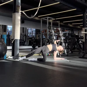 Cadid girl working out on a yoga mat on the gym floor creepshot