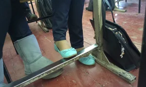 Candid Teen's Feet in Flats Under Desk Closeup Photo