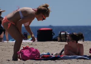 Thick blonde girl in an orange bikini on the beach