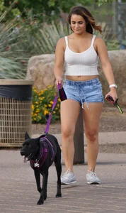 Sexy dog walker in shorts and tank top with friend in blue jeans