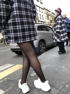 Cute candid girl with legs in black pantyhose waiting on the crosswalk