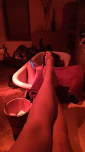 Girl taking a picture of her legs and feed, also of her friend in a bathtub