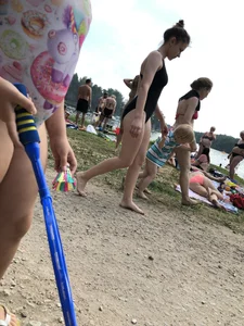 Cute Barefoot Girl in a Black Body Swimsuit Walking on a Road