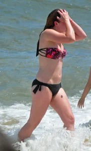 Cute beach girl in little bikini in the water
