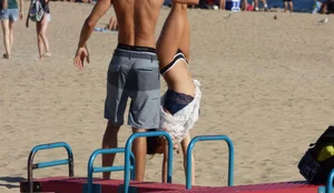 Beach teen in semi thong bikini under see through dress on the beach