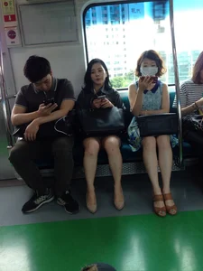 Asian girls in skirts sitting in a public train