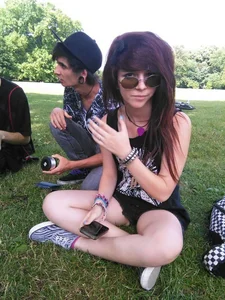 A Cute Candid Teen in Mini Shorts Sitting With Crossed Legs on the Grass in the Park