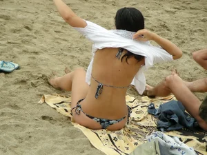 Sexy girl in a blue floral thong bikini at the beach
