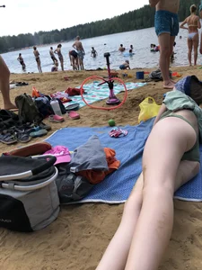 Cute Candid Girl in a Green Swimsuit With Pale Skin Lying on the Beach