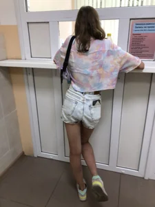 Girl in Denim Shorts With Very Skim Hot Legs And Worn Sneakers at the Reception Desk