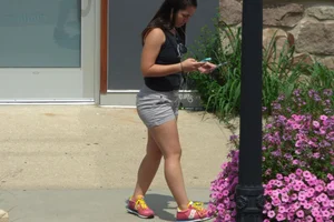 Thick brunette listening to music in shorts