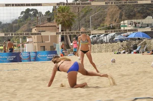 Sexy beach volleyball girl in sport bra top with pokies and blue bikini bottom