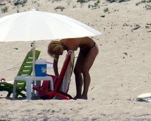 Small boobed topless milf on the beach