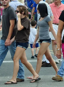 Skinny brunette in tiny denim shorts showing a little cheek