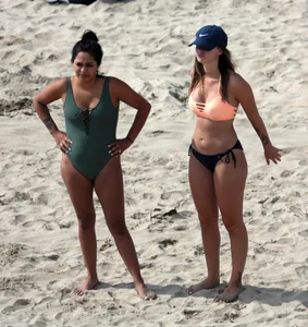 Big boobed babe with pokies in a bikini on the beach with friends
