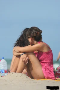 2 topless girls at the beach in thongs