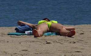 Sexy ass blonde milf on the beach in a thong with cameltoe and bending over