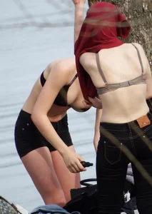 Two gorgeous candid girls secretly changing clothes in a park by a lake, some tits flashing going on, voyeur creepshots