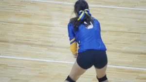 Pretty and sexy brunette college girl in spandex shorts playing volleyball